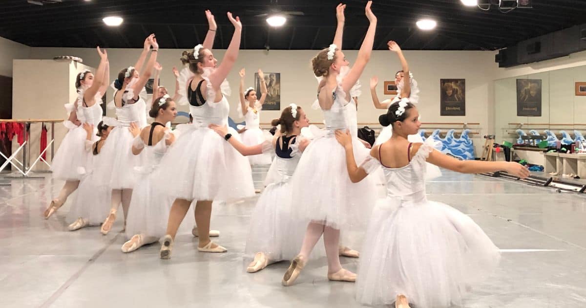 Ballet North dancers in white tutu costumes prepare for upcoming performance at the Performing Arts Center in Excelsior Springs
